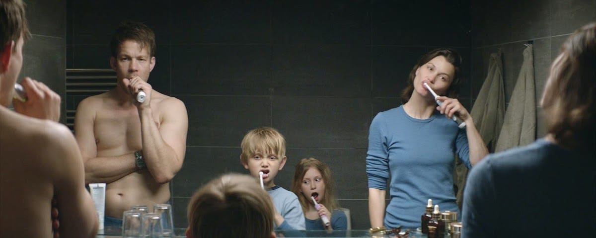 Still from Force Majeure. A family of four is brushing teeth in front of a hotel room mirror.